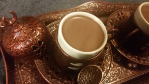 Bronze Turkish coffee cut filled with drinking chocolate.