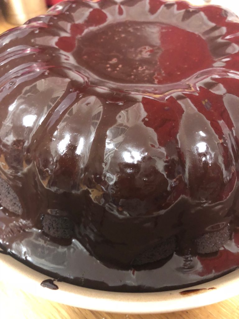 A chocolate cake drowned in chocolate icing.