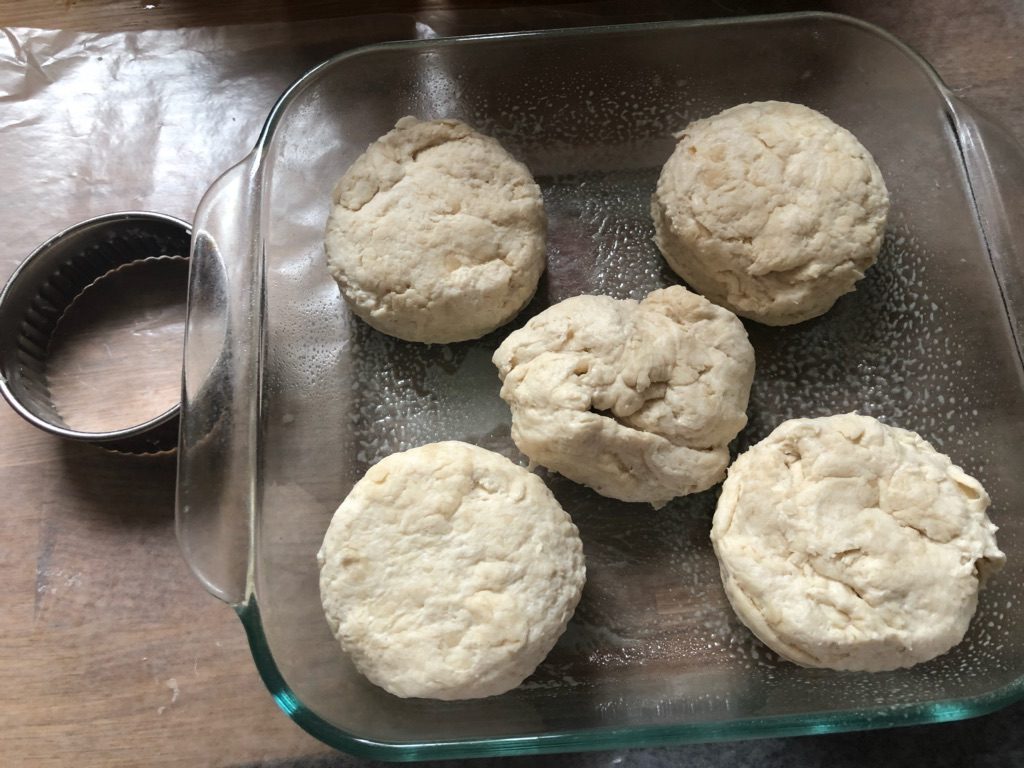 Ready for the oven, biscuits nestled together in a clear glass pan.